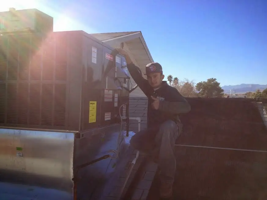 HVAC technician performing AC Tune-Up on a rooftop unit in Myrtle Grove